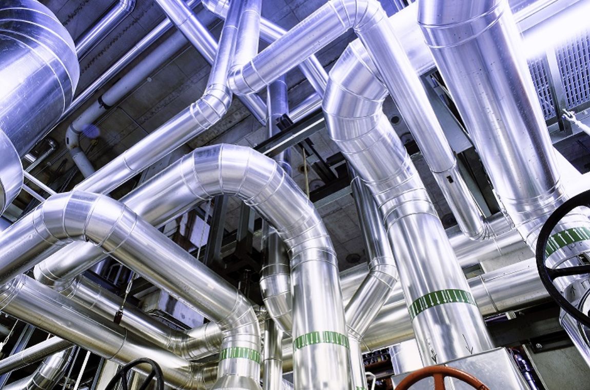 Process industry: ceiling of a manufacturing factory with silver pipes and red and black valves